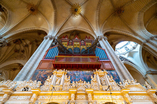 Low angle wide view of the ornate retrochoir and monumental organ under starry ribbed vaults inside La Seo Cathedral in Zaragoza, historic gothic and renaissance architecture.