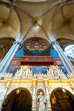 Low angle wide view of the ornate retrochoir and monumental organ under starry ribbed vaults inside La Seo Cathedral in Zaragoza, historic gothic and renaissance architecture.