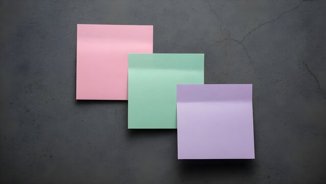 Three blank pastel sticky notes on a dark grey concrete background