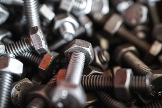 Close Up Steel Nuts and Bolts with Metal Screws and Threaded Industrial Fasteners Isolated on White Background