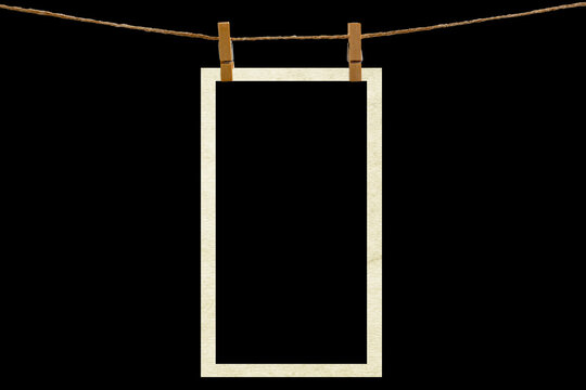 Blank photo frame hanging on a rope with a wooden clothespin. Isolated black JPEG mockup.