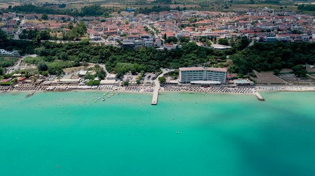 Aerial view of turquoise sea beach with city and pier