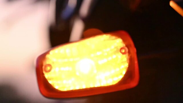 Close-Up of Motorcycle Turn Signal Blinking with Warm Orange Light, Vehicle Safety and Transportation Concept, 4K Footage
