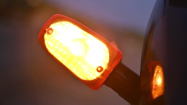 Close-Up of Motorcycle Turn Signal Blinking with Warm Orange Light, Vehicle Safety and Transportation Concept, 4K Footage