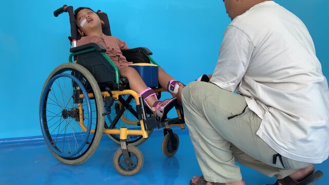 A father helping his young son put on shoes over an ankle-foot orthosis (AFO) brace.