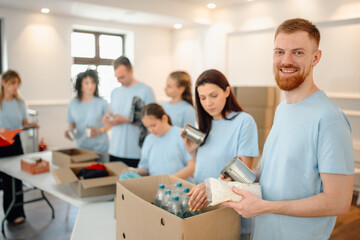 Fototapeta premium Volunteers sorting food donations for charity and community service