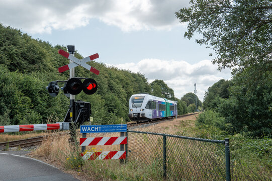 Lievelde, Gelderland, Netherlands, Train approaching level crossing with barrier in lievelde