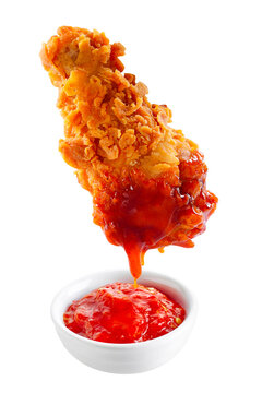 Chicken dipped in chili sauce on white background