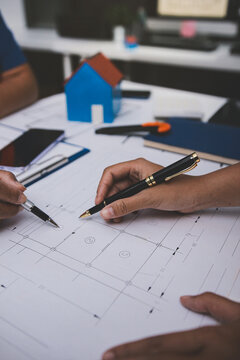 engineer and an architect reviewing blueprints and construction plans together at a bustling construction site