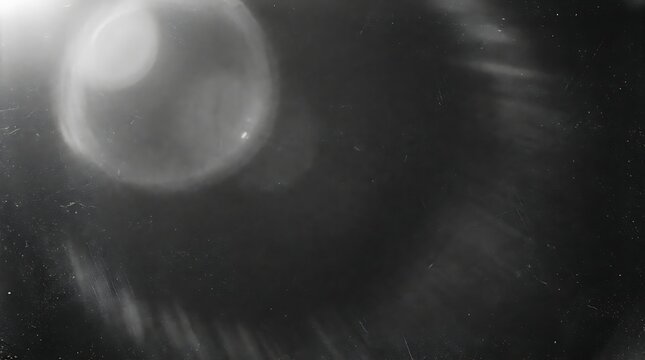 Abstract black and white background with subtle lens flare glow and soft light leaking overlay texture.