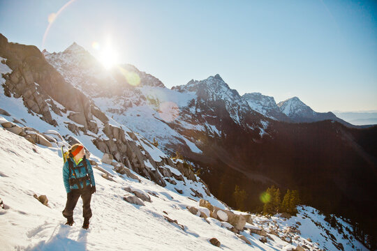 Hiker looking at sunlit snowy mountain range