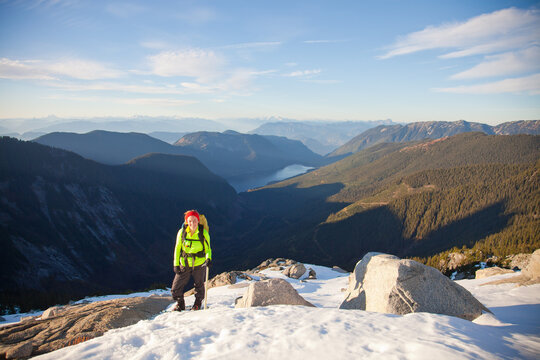 Woman hiker smiles from a snowy mountain summit