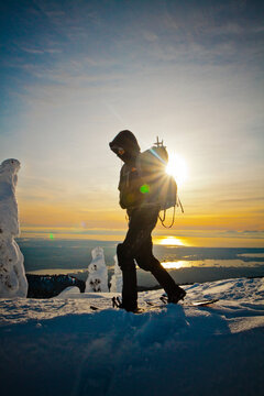 Backpacker snowshoeing at sunset above Vancouver, B.C.