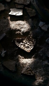 Ancient pottery shards reveal history&rsquo;s secrets on a weathered stone surface bathed in soft light