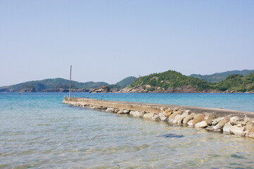 Fototapeta premium Concrete Pier on Crystal Clear Sea near a Fishing Harbor in Shimane Japan