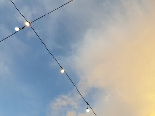 Obraz premium Minimal String Lights Against Blue and Golden Sunset Sky with Copy Space