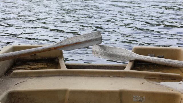Wooden oars at rowing boat. Dark water and lake.