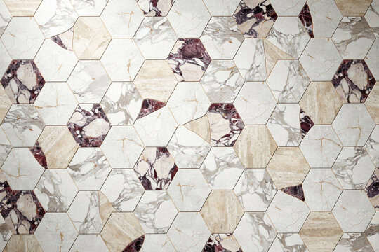 Geometric hexagonal tile pattern featuring a mix of white marble and dark purple veined stone textures creating a luxury wall surface