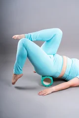 Woman doing pelvic floor, abdominal muscles, legs and lower back exercises using foam massage roller, myofascial release or pilates concept © staras