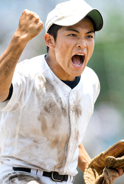 拳を上げて雄叫びを上げる男性野球選手
