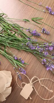 Fresh lavender bouquet kraft tag background video. Purple flower stems with blank craft label and jute twine on wooden table. Creative process or handmade product packing concept for small business.