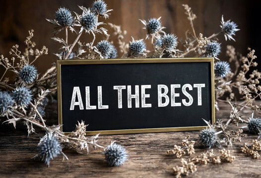 Beautiful black signboard with all the best text surrounded by dried thistle flowers arrangement