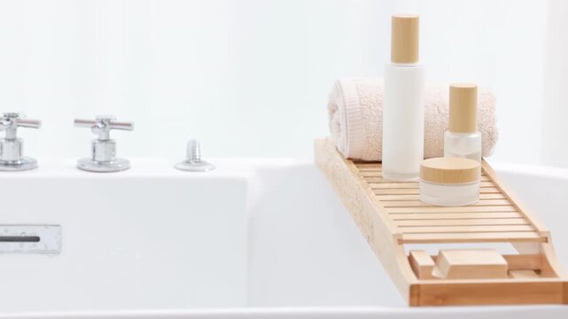 Pretty elegant woman standing on edge of bathtub, turning on faucet tap to run a bath of jacuzzi with foam soap and hand tests water temperature before enjoying self-care weekend day in hot water