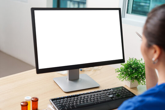 Veterinarian looking at blank computer monitor screen mockup on desk