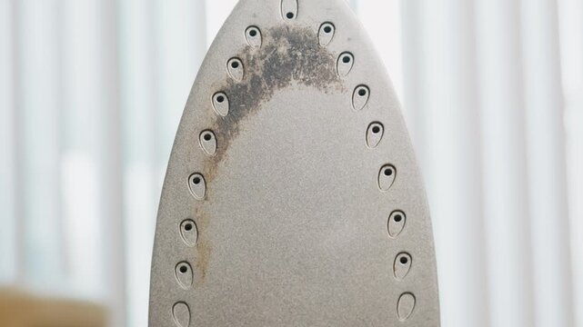 Scorched soleplate of a steam iron close up