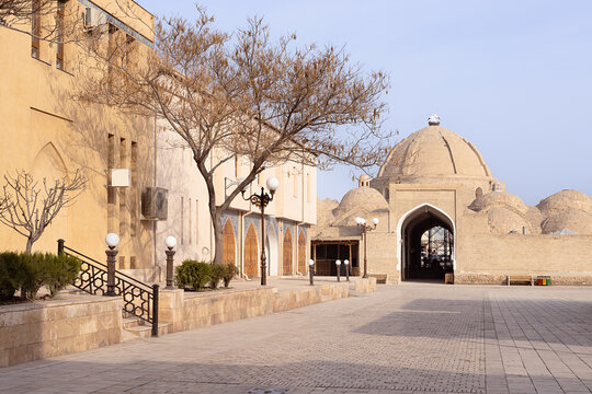 Toqi Zargaron domed bazaar entrance in the historic old town of Bukhara, Uzbekistan. Empty plaza with traditional brick domes and arched gateway, ideal for travel and heritage publications.