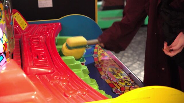 Person playing whack a mole arcade game
