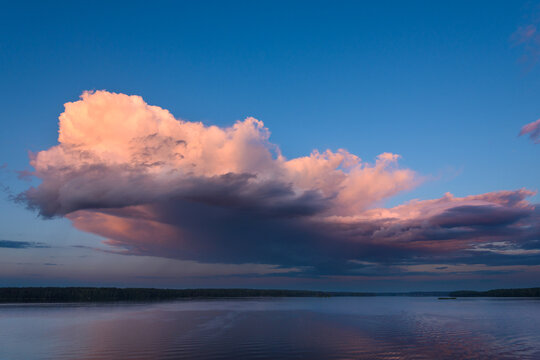 Sunset Landscape with Dramatic Pink Storm Cloud over Calm River