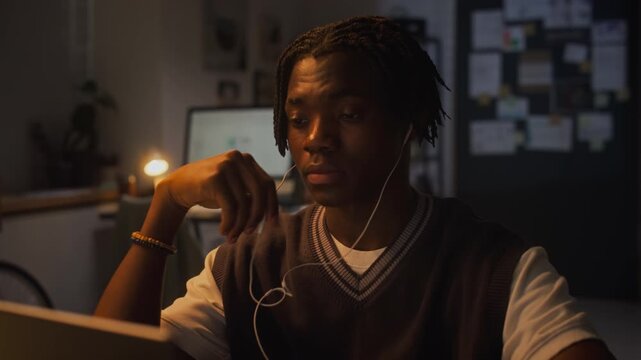 African American young adult man rubbing tired eyes while working late on laptop in office. Clip is ideal for commercial videos about employee burnout, stress, and overwork
