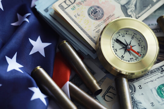 Money bill with golden Compass. Bullets and cartridge cases as a military concept. Close up US Currency and compass. business, financial idea, concept, symbol of crisis, inflation