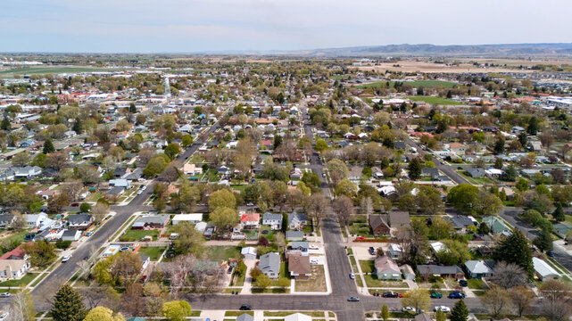 Aerial view of a dense residential neighborhood with tree lined streets stretching to the horizon.