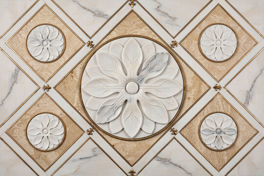 A decorative wall panel featuring white marble flower carvings set within diamond shaped frames of beige stone and thin gold metal borders