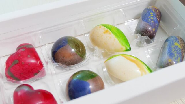 Artisan painted chocolate bonbons in box tray close up