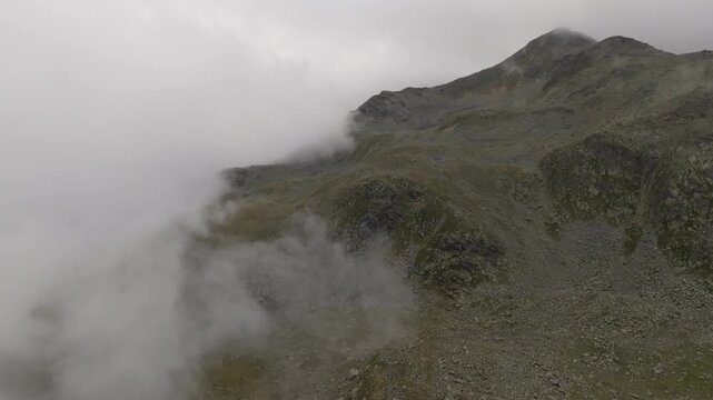 Aerial drone view above Timmelsjoch mountain pass connecting Austria and Italy across the Tyrol Alps with magnificent cloud covered peaks spectacular nature landscapes and European tourism