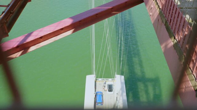Person exiting car on suspension bridge support pylon
