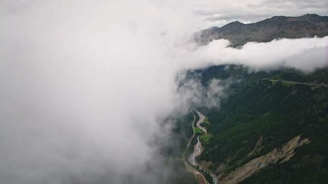 Spectacular aerial panorama of Tyrol Alpine mountains emerging through clouds with rugged rocky ridges green fields untouched wilderness and inspiring tourism across Europe