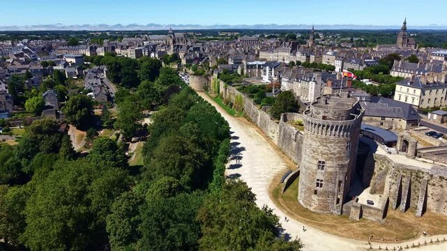 Ch&acirc;teau de Dinan with the 14th-century Donjon, machicolations, curtain wall, round tower and dry moat in Dinan, C&ocirc;tes-d'Armor, Brittany, France, overlooking the medieval town, drone forward flyover.