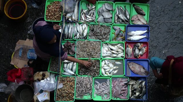 A bustling fish market comes alive during the early morning hours, where vendors and buyers engage in the daily trade of fresh seafood and fish. Operating from around midnight until 7am