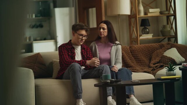 Caring mother listening to her upset teenage son, offering comfort and support