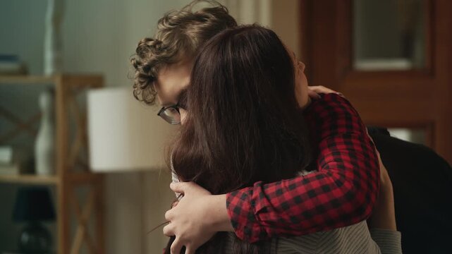 Joyful son embracing his mother after returning from university, family reunion