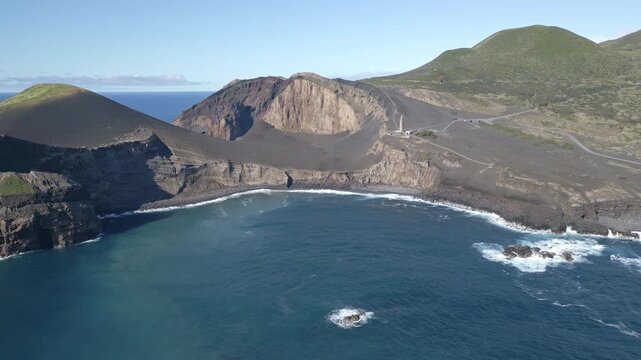 Aerial view of volcanic coastline and cliffs with ocean waves at Capelinhos, Faial Island
