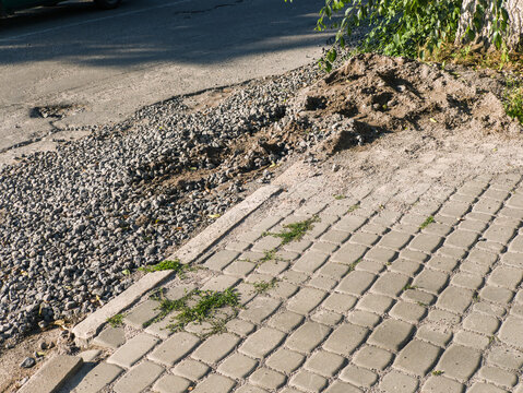 Paved Cobblestone Walkway Meeting Gravel Road Border under Direct Sunlight