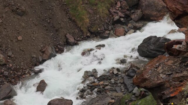 4K Closeup shot of river stream flowing in the mountain valley during the summer season as seen during the Ghepan Ghat Lake Trek or Aliyas Lake Trek near Sissu village in Lahaul Valley, India