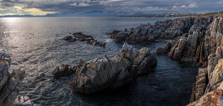 Sweeping view across Walker Bay from De Kelders toward Hermanus in the Overberg, Western Cape, South Africa, showcasing a dramatic coastal landscape, ocean, cliffs, and scenic travel destinations.