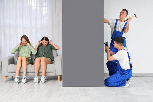 Young women suffering from loud neighbours renovating at home