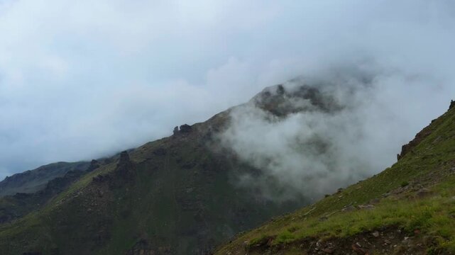 4K Landscape shot of clouds around Himalayan mountain peaks during the monsoon season as seen from Sissu village in Lahaul and Spiti district, Himachal Pradesh, India. Natural background.